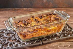 Clafoutis Roquefort cheese with mushrooms in glass form on metal stand
