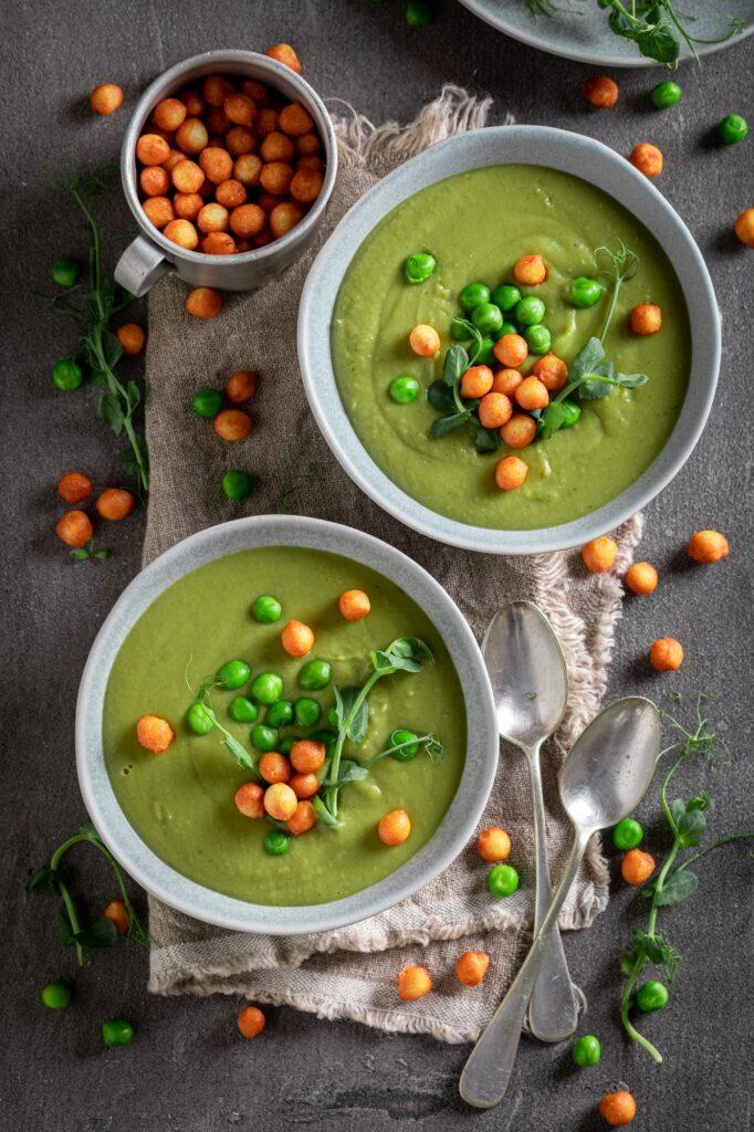 Homemade pea soup with peas puff and cream.