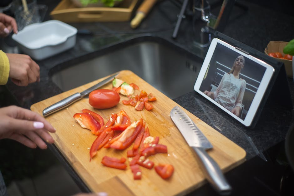 Person using a touchscreen recipe guide while cooking in a kitchen