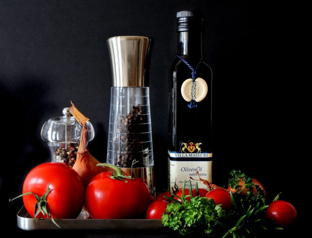Affichage vibrant d'ingrédients frais comprenant des tomates, des herbes et de l'huile d'olive pour une cuisine saine.