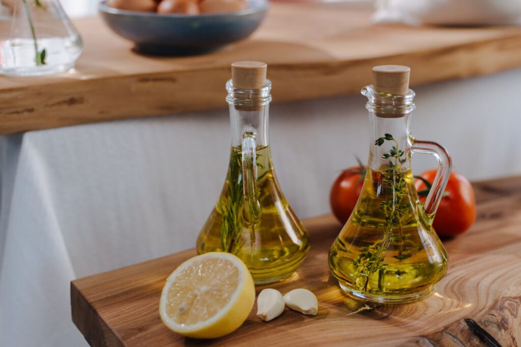 Ail frais et citron avec des bouteilles d'huile d'olive, parfait pour la cuisine italienne. Évoque la fraîcheur et la saveur.