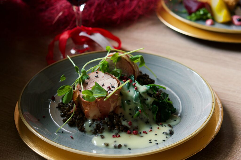 Un délicieux filet mignon de porc aux lentilles, aux épinards et à la sauce crémeuse au citron, parfait pour un dîner gastronomique.