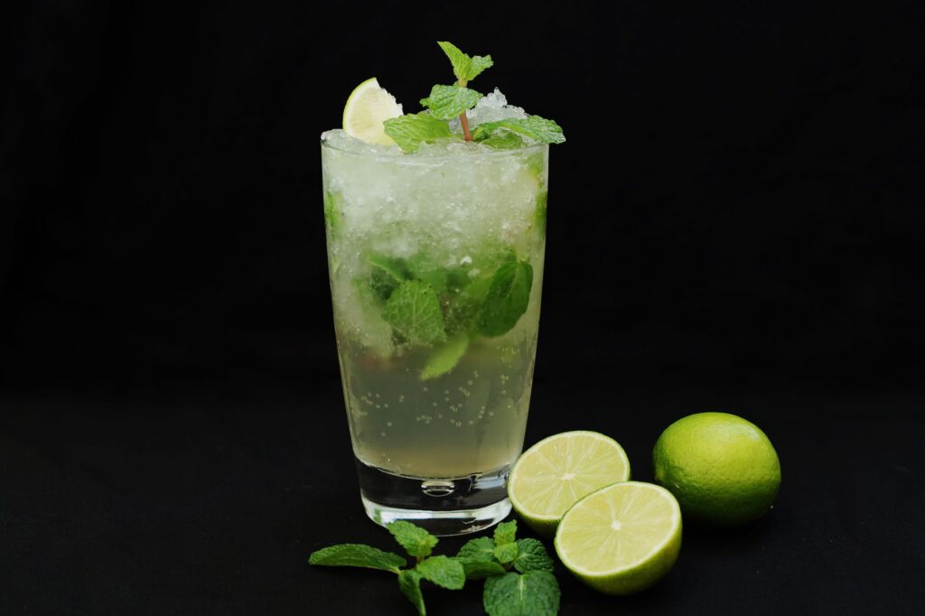 Cocktail mojito glacé garni de citron vert et de menthe fraîche.