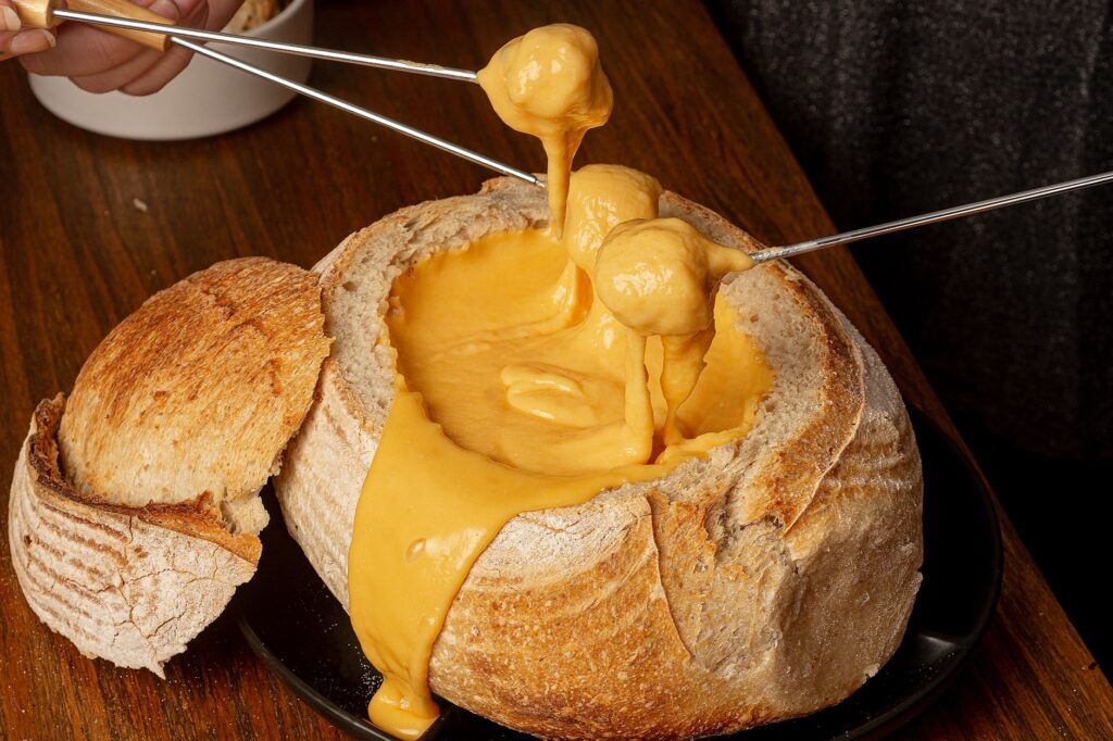 Délicieuse fondue au fromage dans un pain rustique sur une table en bois.