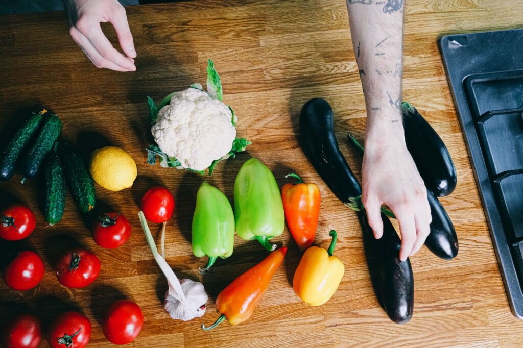 Des légumes colorés, y compris des poivrons, des tomates et des aubergines, disposés sur un plan de travail de cuisine.