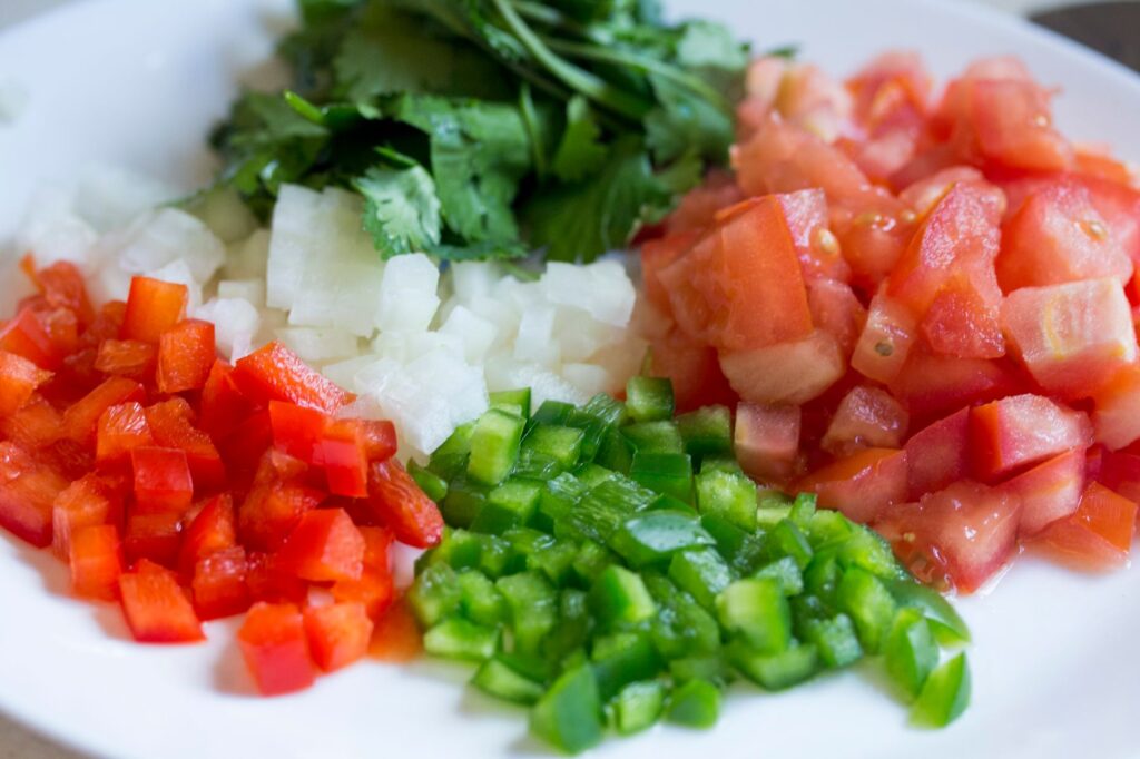 Légumes colorés en dés sur une assiette, parfaits pour une cuisine saine et la préparation de repas.