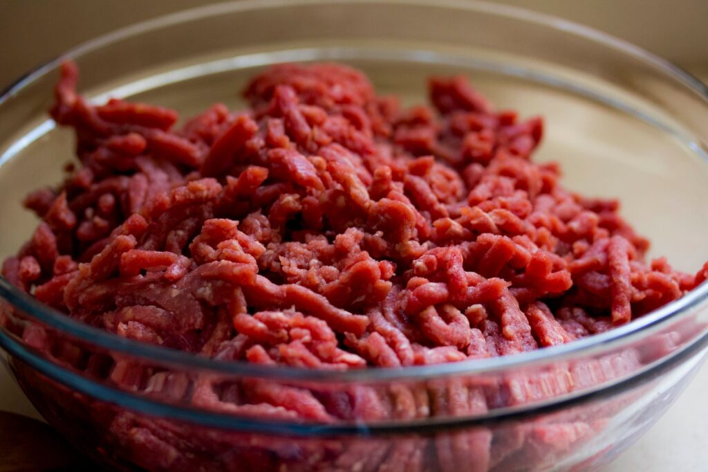 Image de haute qualité de viande de bœuf hachée fraîche dans un bol en verre, idéale pour des thèmes culinaires et alimentaires.