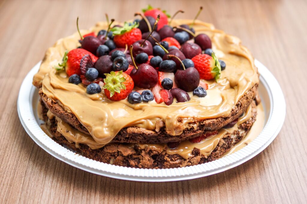 Délicieux gâteau au chocolat en couches avec des baies fraîches et une crème au beurre de cacahuète sur une assiette.