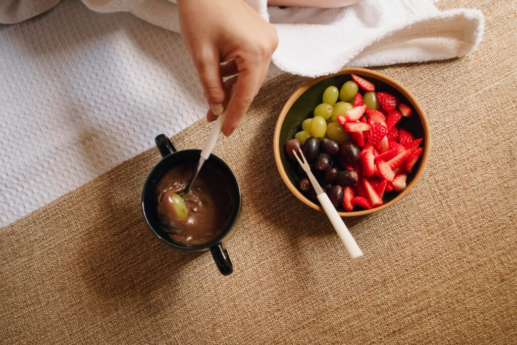 Vue du dessus d'un délicieux assortiment de fruits et de chocolat au fondue avec des fraises, des raisins et une tasse de trempage.