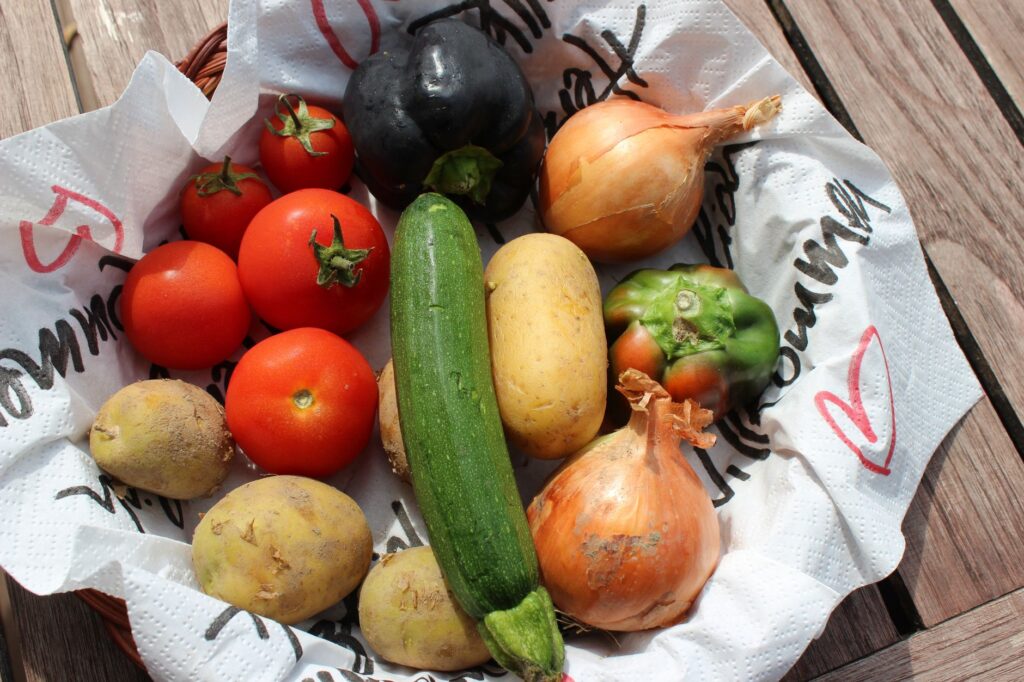 Vue de dessus de légumes biologiques frais, y compris des tomates, des oignons et des courgettes dans un panier.