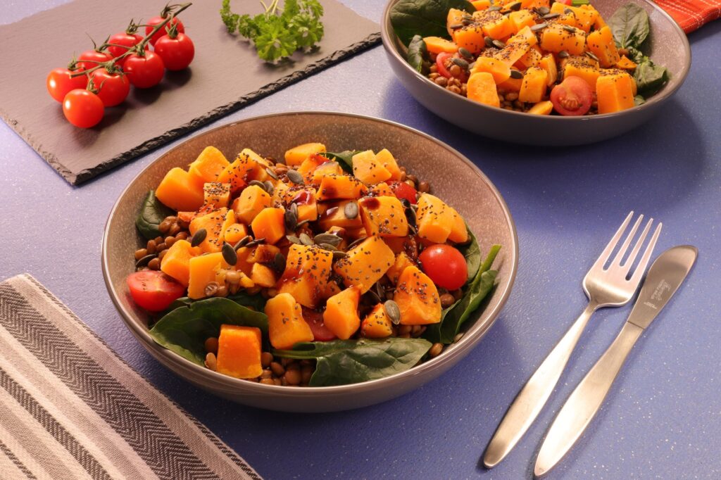 Une salade vibrante de courge butternut avec des lentilles et des tomates cerises, parfaite pour un repas nutritif.