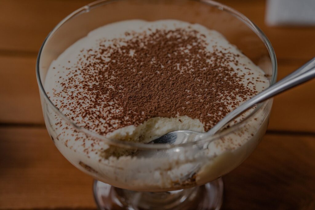 Régalez-vous avec un dessert tiramisu crémeux et riche, garni de cacao en poudre.