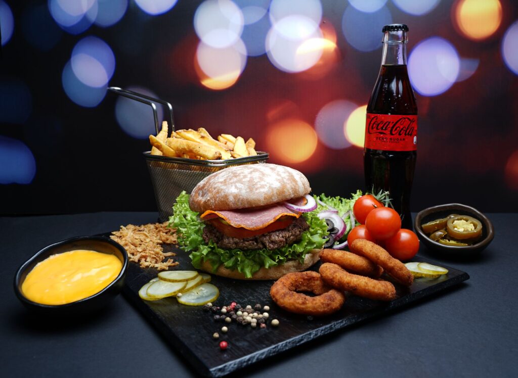 Un délicieux repas de hamburger avec frites, sauce au fromage et soda, parfait pour un festin.