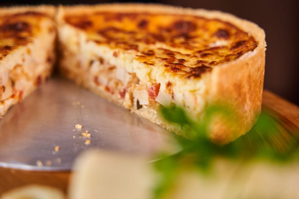 Quiche maison tranchée avec une croûte dorée, parfaite pour une gourmandise salée.
