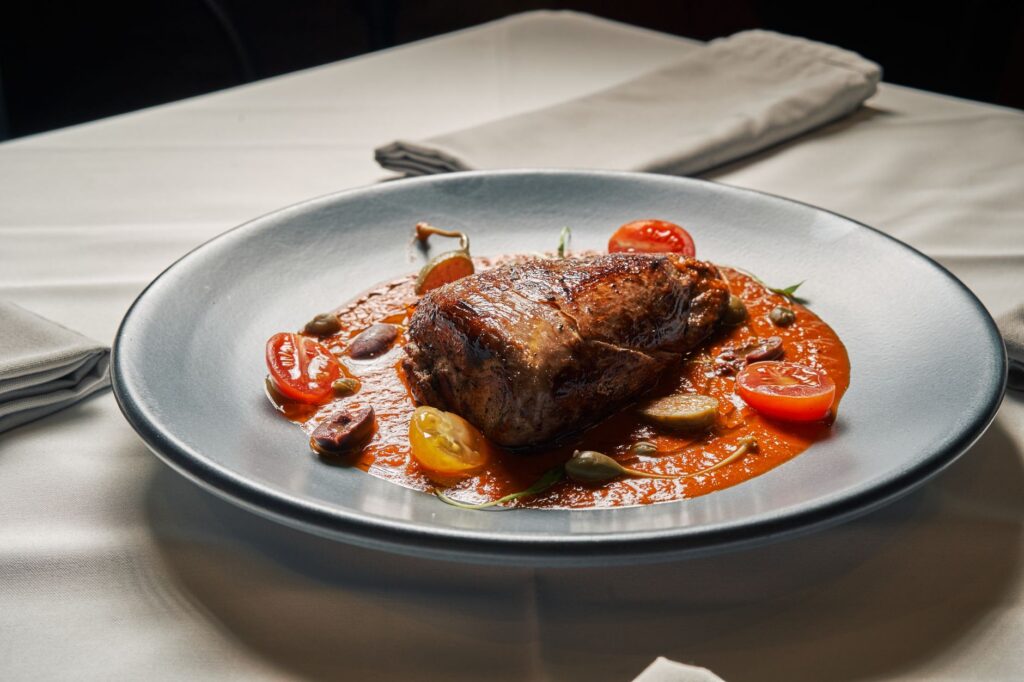 Un steak de bœuf juteux servi avec des tomates cerises fraîches et une riche sauce tomate.