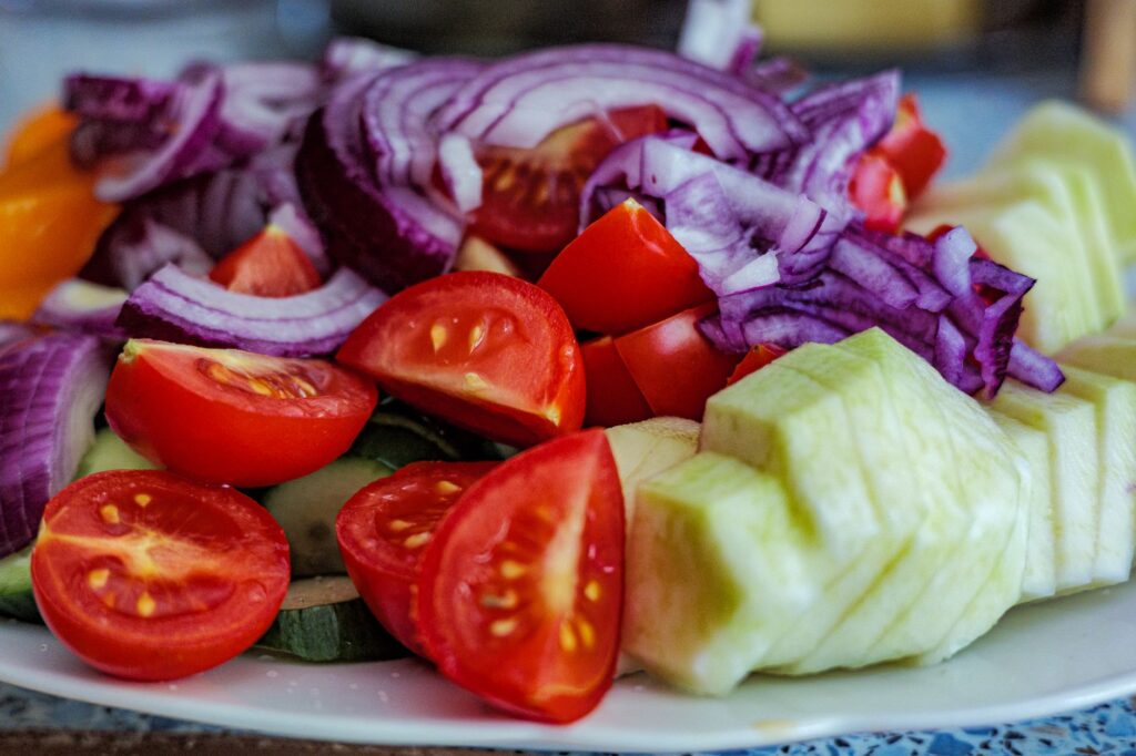 Salade d'été colorée composée de tomates, de concombres et de tranches d'oignon rouge.