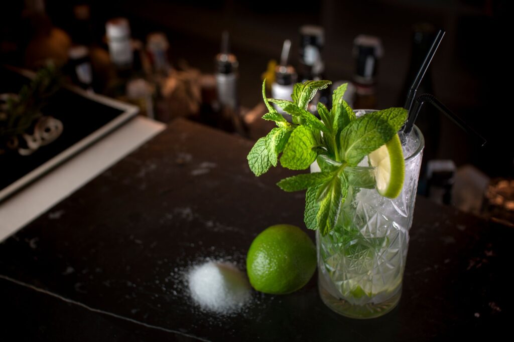 Un élégant mojito à la menthe et au citron vert, servi sur un comptoir de bar, parfait pour les amateurs de cocktails.