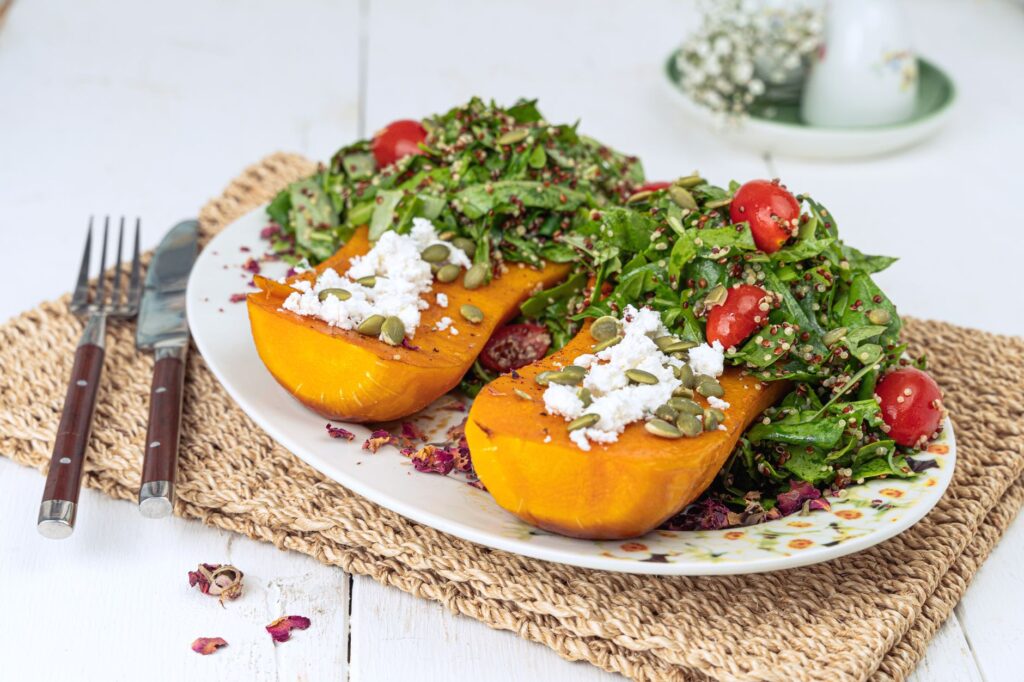 Gros plan de courge butternut rôtie avec salade de quinoa, tomates cerises et feta.