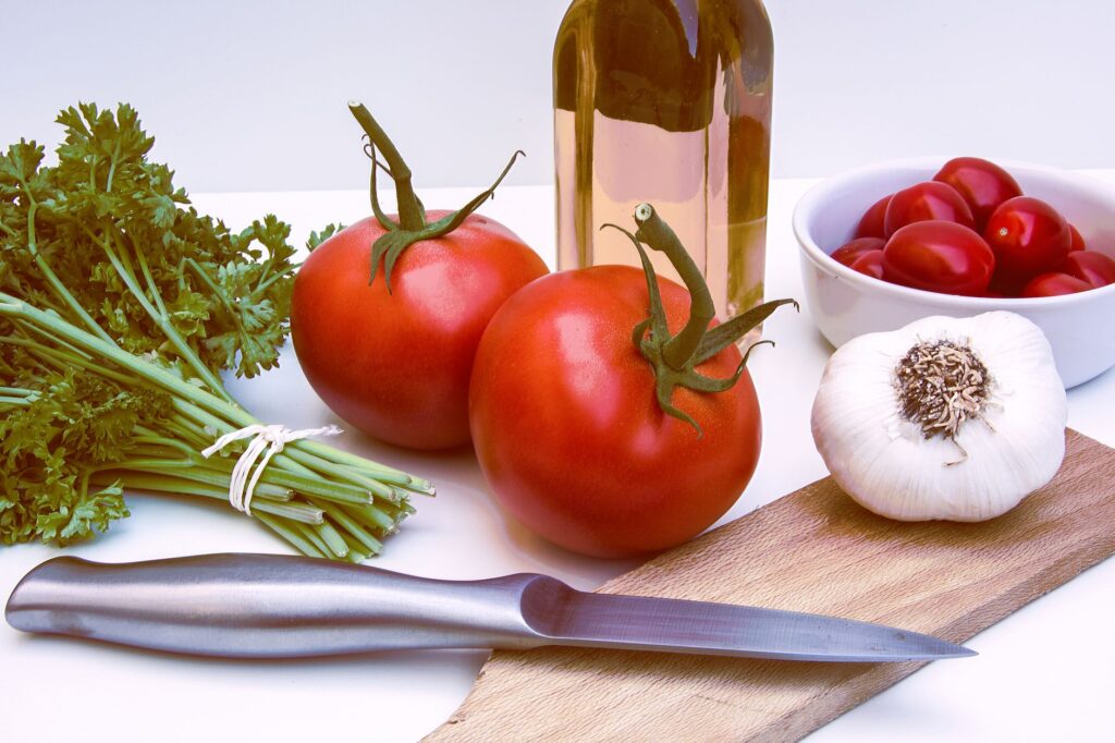 Ingrédients frais pour une cuisine saine avec des tomates, de l'ail et des herbes sur une planche à découper.