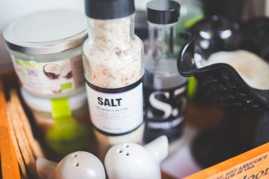 Vue rapprochée de divers condiments de cuisine, incluant un shaker à sel et d'autres contenants.