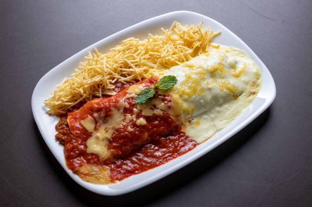 Plat de pâtes appétissant recouvert d'une sauce tomate et fromage riche, servi avec des frites croustillantes.