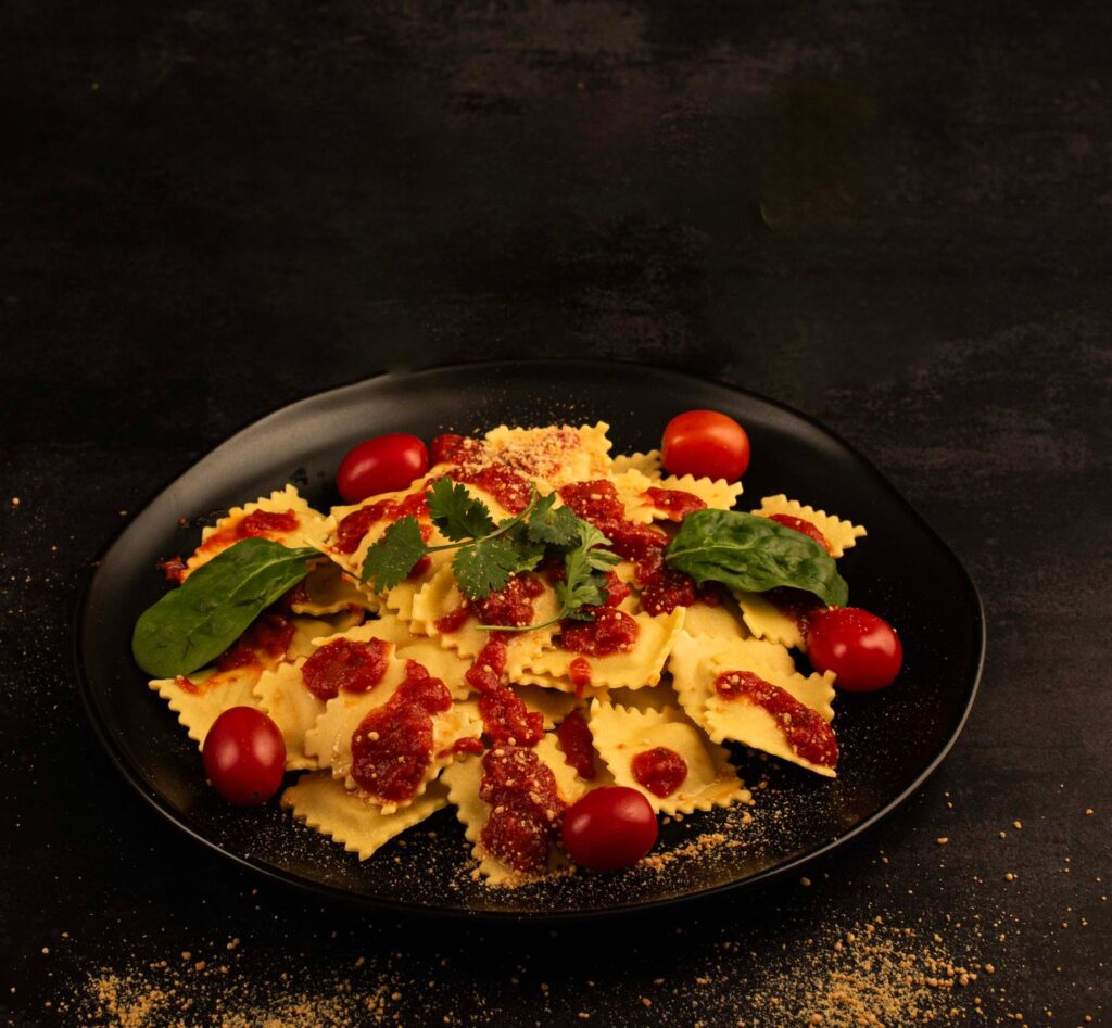 Délicieux raviolis nappés d'une riche sauce tomate et garnis de feuilles d'épinards.