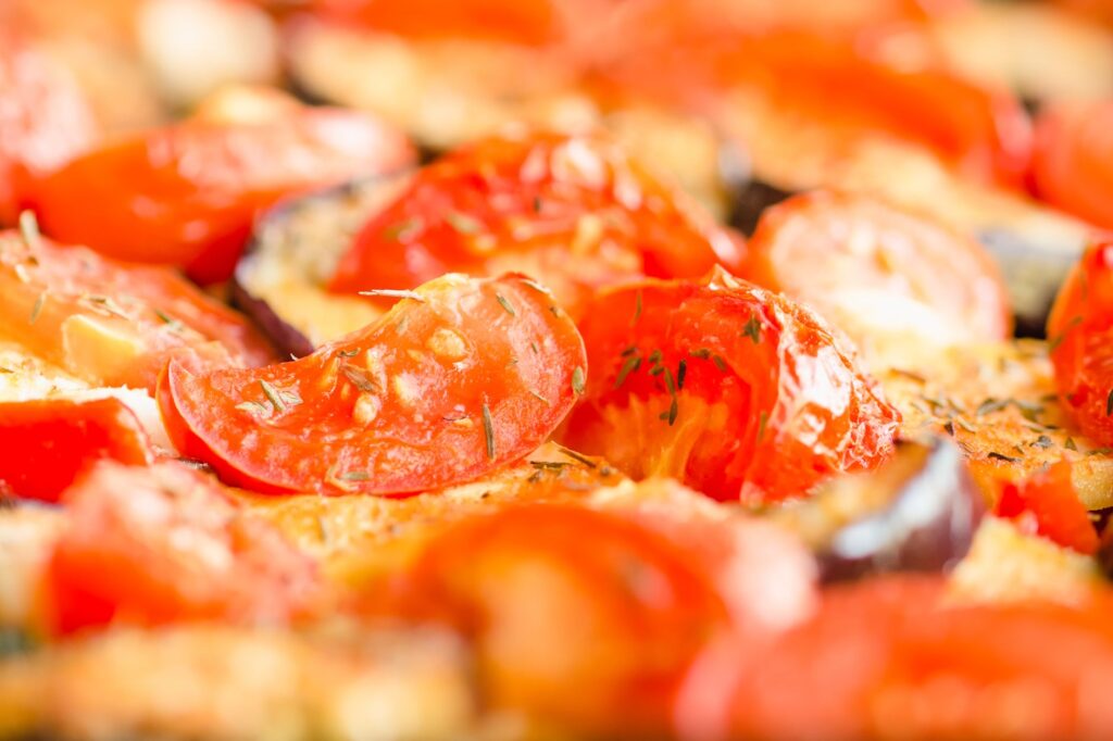 Gros plan vibrant de tomates rôties et de légumes avec des herbes, parfait pour les blogs culinaires.