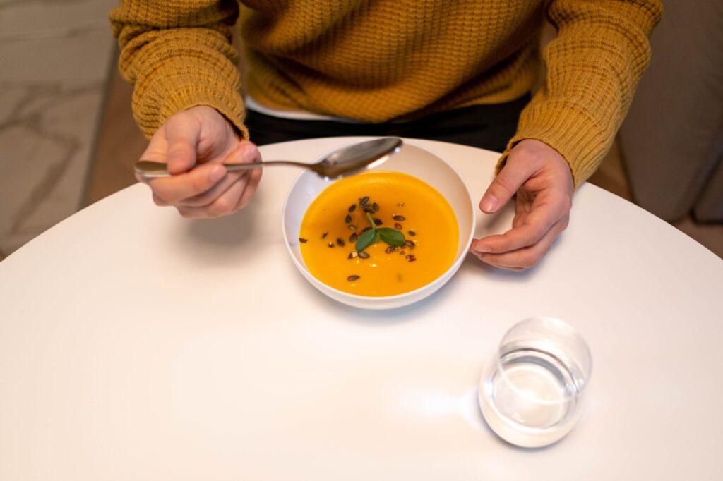 Un bol chaud de soupe au potiron garni et prêt à être dégusté à l'intérieur.